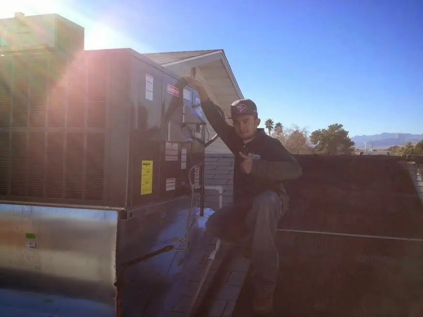 HVAC technician performing Air Duct Repair on a rooftop unit in Idaho Falls